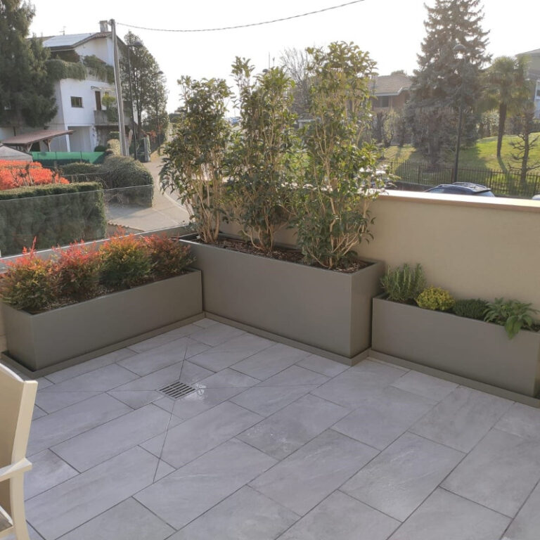 Fioriere in alluminio grigio angolari con piante verdi collocate su terrazzo