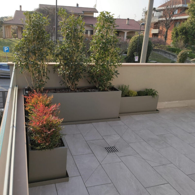 Fioriere in alluminio grigio angolari con piante verdi collocate su terrazzo